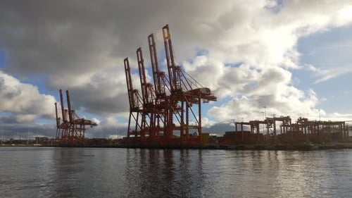 Gantry Cranes For Loading And Unloading At Container Port During A Cloudy Day. POV Shot