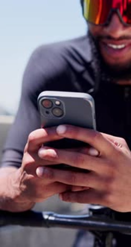 Cyclist, hands and man with phone in city for fitness app, track performance and cycling break