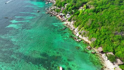 Sandy beach shore with beautiful resort surrounded by clear sea water.