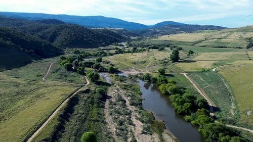 Drone aerial landscape of winding river creek inlet water stream in bushland forest valley on rural