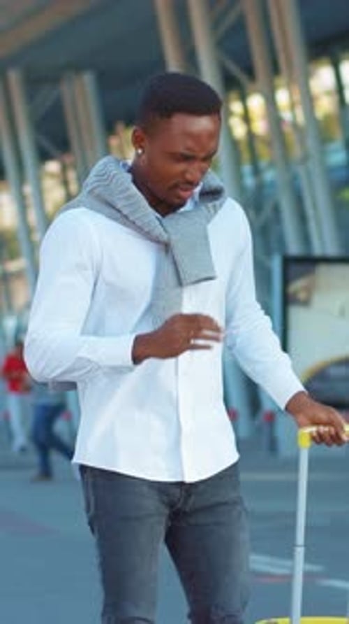 A Stylish Traveler with Luggage at the Airport Displaying Fashion and Confidence