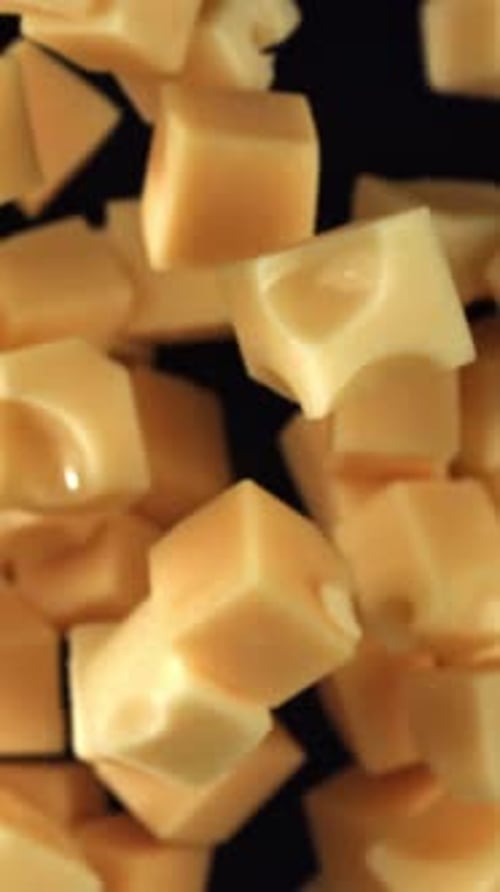 Maasdam Cheese Flies Up and Falls Down on a Black Background Filmed on a Highspeed Camera at 1000