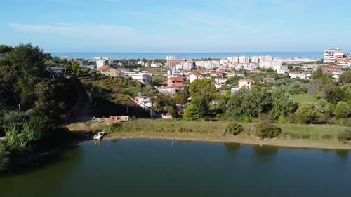 Aerial above albanian coastal village with hotels and apartment buildings.