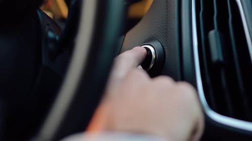 Close-up of Person Pressing a Start Engine Button with a Finger. Starting a Car. Car Interior