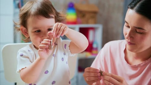 Child and Woman Playing with Clay Indoors