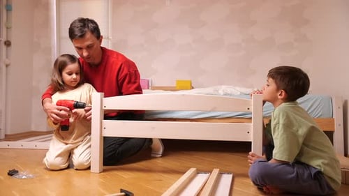 Father and Children Assembling Wooden Bed at Home