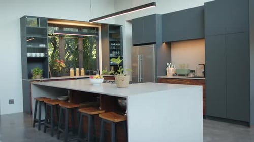 Modern kitchen with island, bar stools, and sleek cabinets in contemporary home, copy space