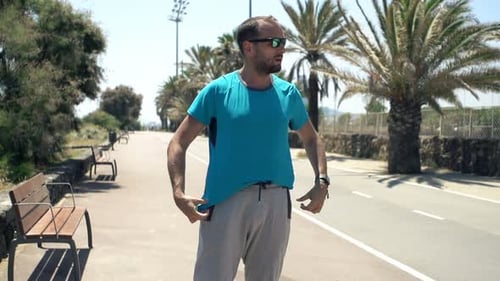 Male Jogger Putting on Shirt and Start Jogging in City Park, Super