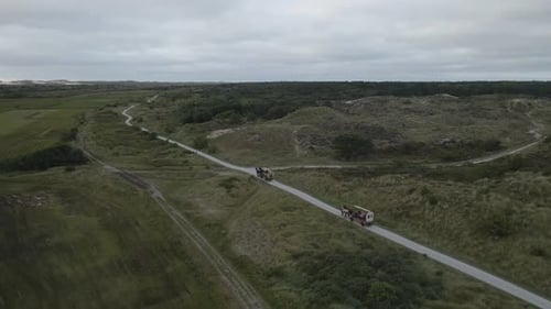 Luftaufnahme von Pferd und Wagen mit Touristen auf unbefestigter Straße in der Natur, Niederlande