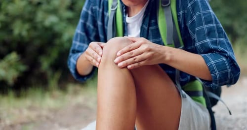 Woman Massages Sore Knee Outdoors