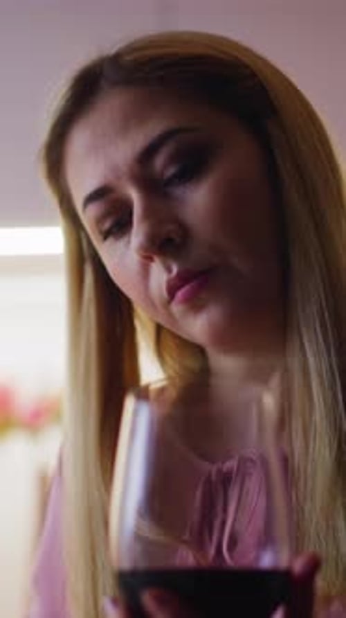 Thoughtful Woman Looks at Red Wine Before Degustation