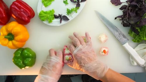 Preparing sushi rolls, cutting and placing on the plate, serving of a dish in the restaurant