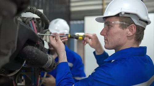 Both of engineers working together in a robotic arm factory,
