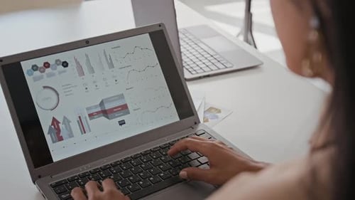 Geschäftsfrau gibt Daten in den statistischen Unternehmensbericht auf dem Laptop ein