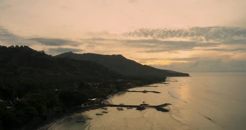 Aerial Ocean Waves Rolling Toward Tropical Beach at Golden Sunset