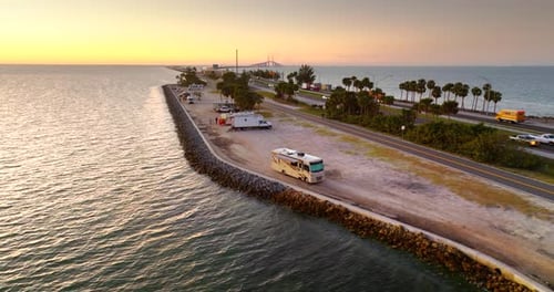 Recreational Vehicles Parked at Florida Campsite with Sunshine Skyway Bridge in Background During