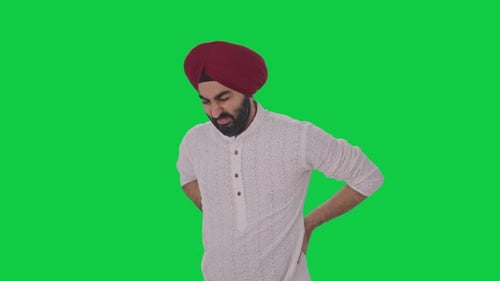 Sick Sikh Indian man suffering from back pain Green screen