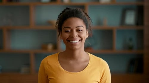 Smiling Young Woman with Curly Hair Posing Indoors