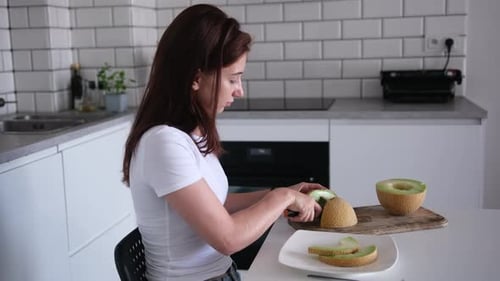Fille coupant du melon