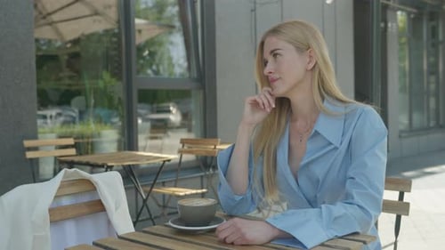 Blonde Woman Enjoying Morning Coffee Outdoors At Cafe Terrace In Blue Outfit