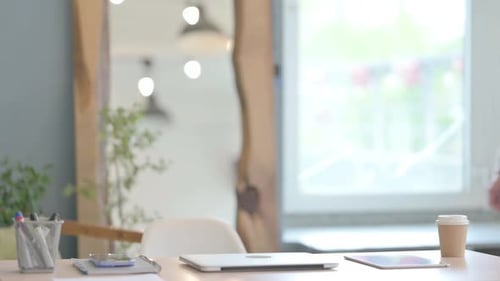 Young Businessman Coming to Office and Starting Work on Laptop