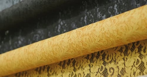 Close Up of Gold and Black Lace Fabric Rolls