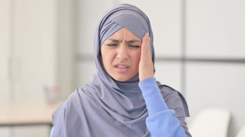 Woman in Hijab Experiencing Headache in Office