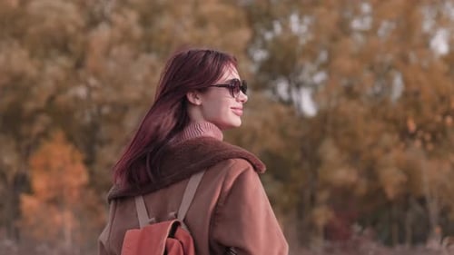 Woman Walking in Autumn Forest Turning Head to Smile