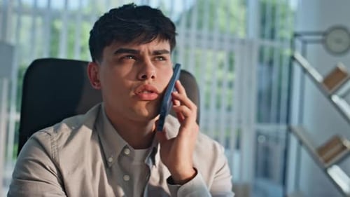 Young Adult Talking on Smartphone in Office Setting