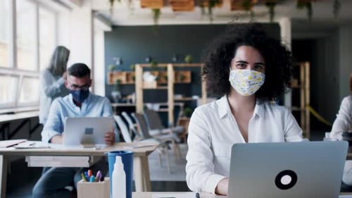Team of businesspeople in office wearing face masks during coronavirus pandemic