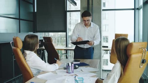 Business Meeting in Modern Office with Team Discussing Project Details in a Collaborative Atmosphere