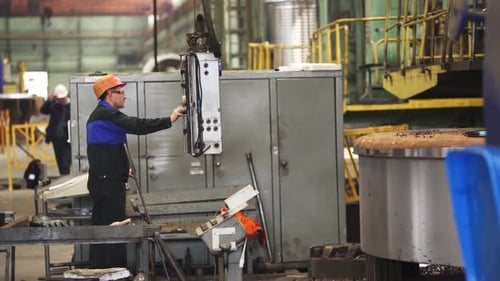 Factory Worker Operating Heavy Machinery Producing Metal Detail Stock Clip