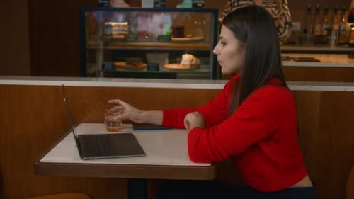 Attractive young woman is working thoughtfully at laptop. Woman works with clients on freelance