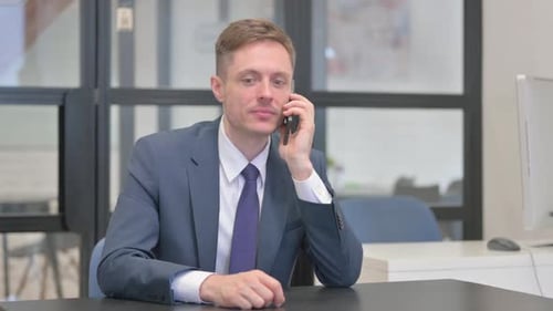 Mature Adult Businessman Talking on phone in Office