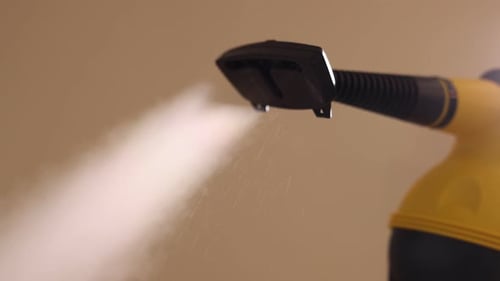 Yellow steam cleaner spraying steam in close up