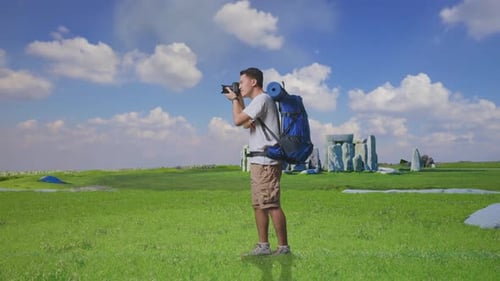 Young Adult Taking Pictures in a Green Field