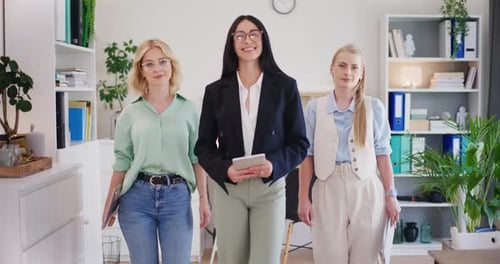 Three Confident Businesswomen Walking Forward in Office