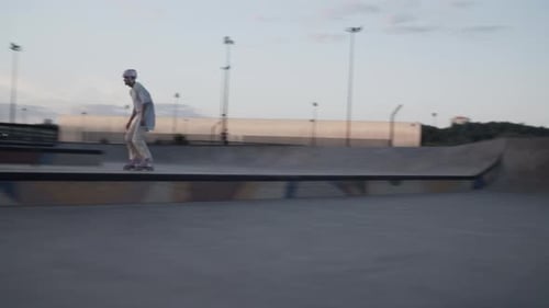 Un homme portant un casque patine sur une croupe en béton dans un skate park urbain