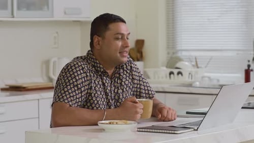 Man Video Conferencing in a Bright Kitchen