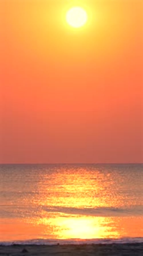 Lever de soleil vibrant sur l'océan tranquille avec reflet du soleil doré