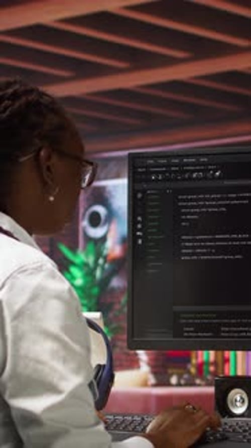 Young Woman Programmer Types at Computer in Office