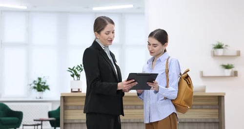 Receptionist working with guest at reception indoors