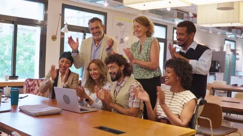 Colleagues Celebrate Success Looking at a Laptop in Office