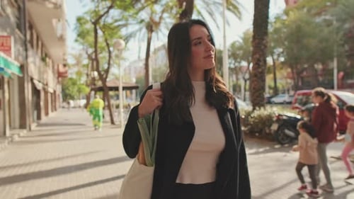 Hermosa joven caminando por la calle con bolsa de supermercado