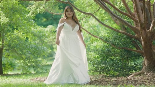 Woman in Elegant Gown Twirls in Lush Park