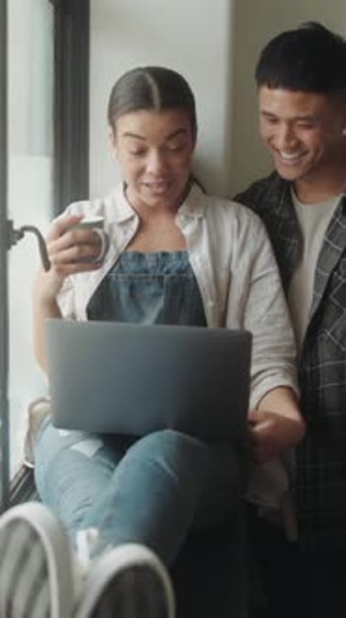 Happy Couple Relaxing At Home Using Laptop