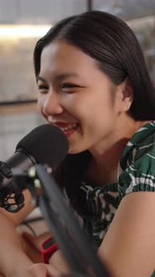 Smiling Young Woman Talking Into Microphone