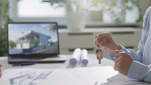 Hand of Real Estate Agent Giving Keys to Customer above Office Desk