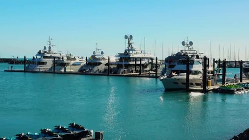 A group of expensive luxury Super yachts are moored in the tranquil waters of Shute Harbour in North