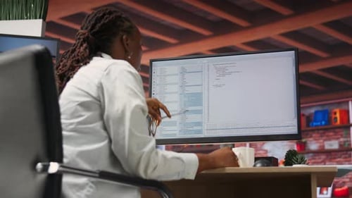 Woman Working at Computer in Brightly Lit Office